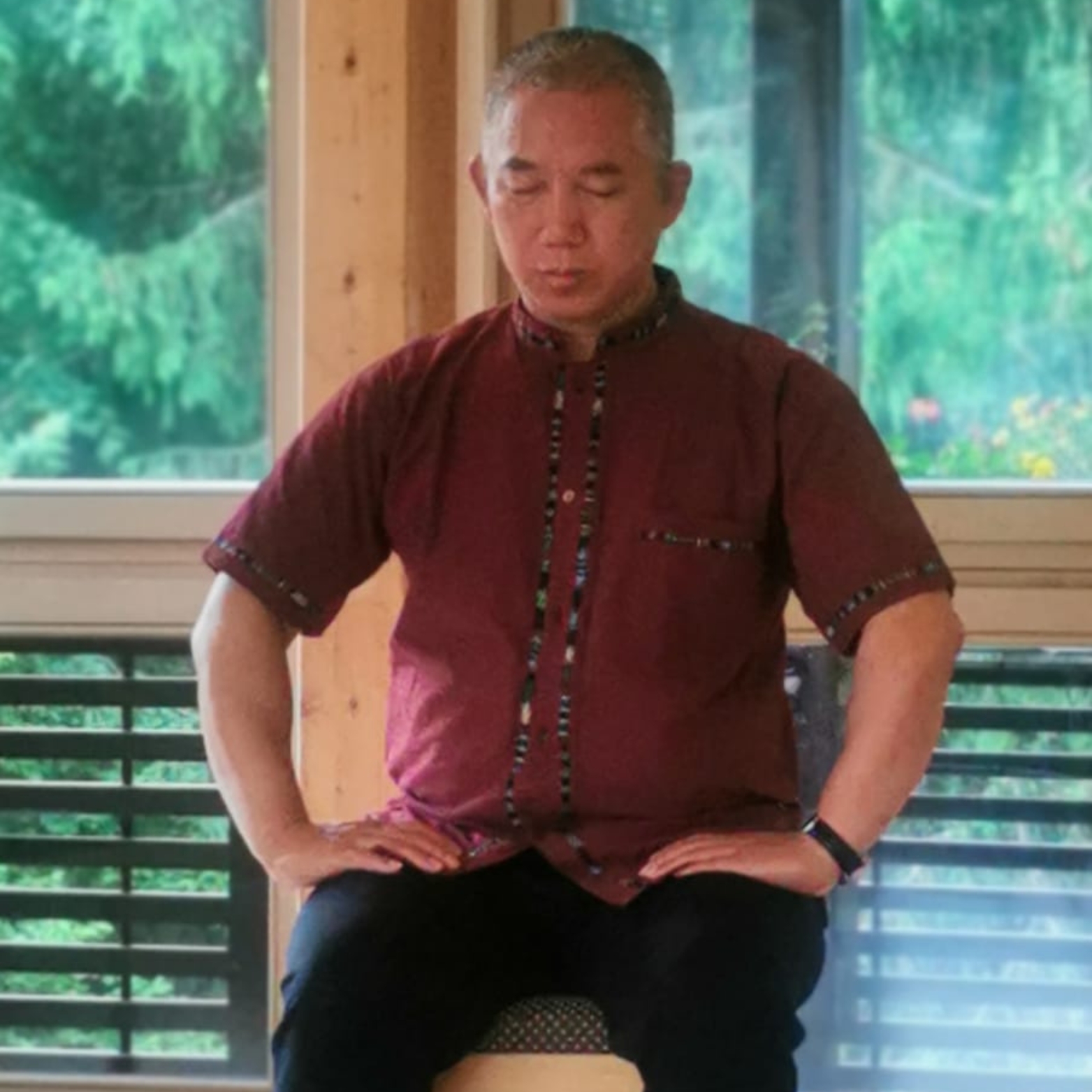 Qigong Master Yuantong Liu in a sitting Zhineng Qigong posture